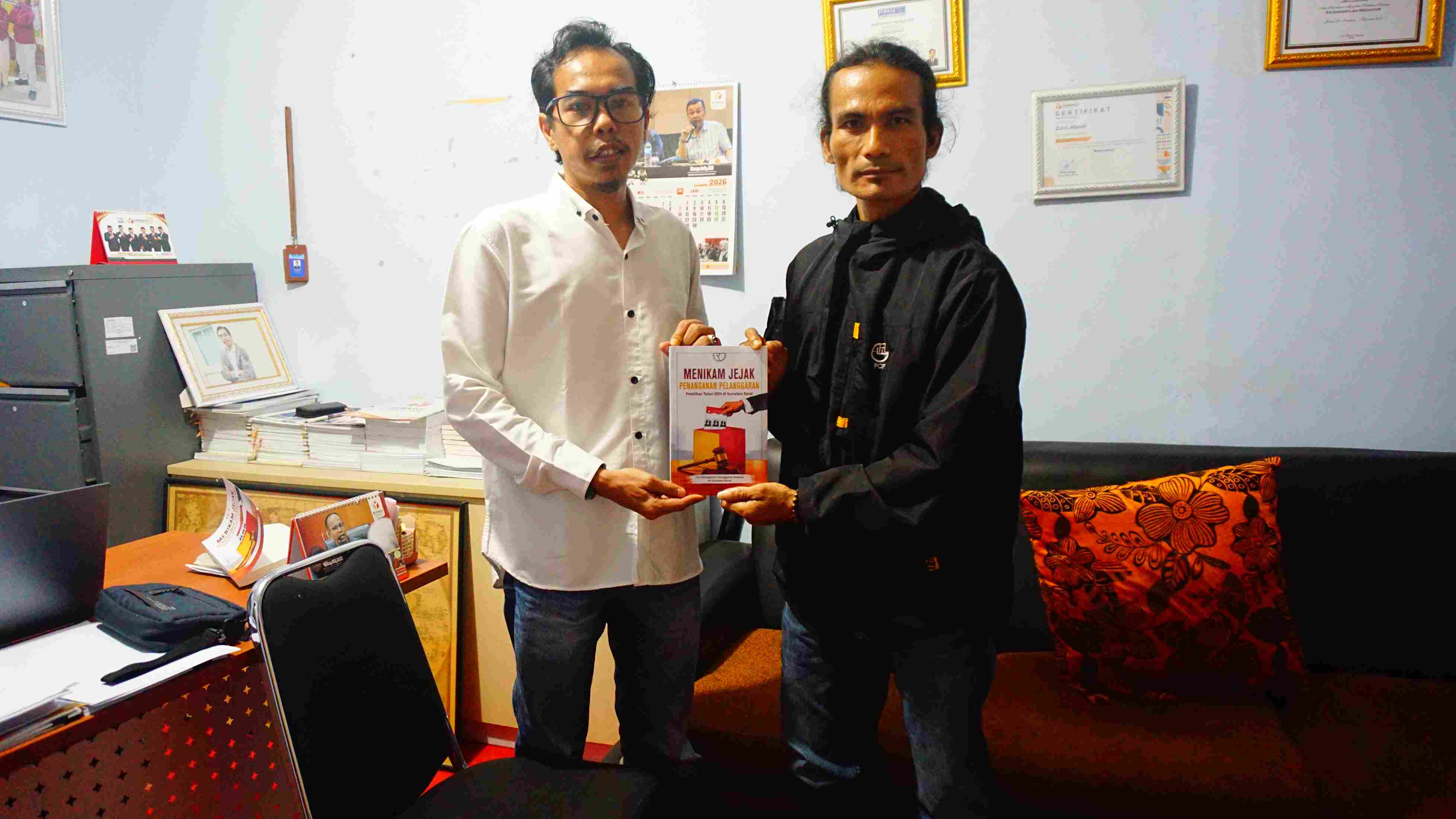 Anggota Bawaslu Pasaman (Zaini Afandi) menyerahkan buku Jejak Penanganan Pelanggaran Pemilihan 2024 kepada Komunitas Rumah Mentari di kantor Bawaslu Pasaman, Rabu (20/5)