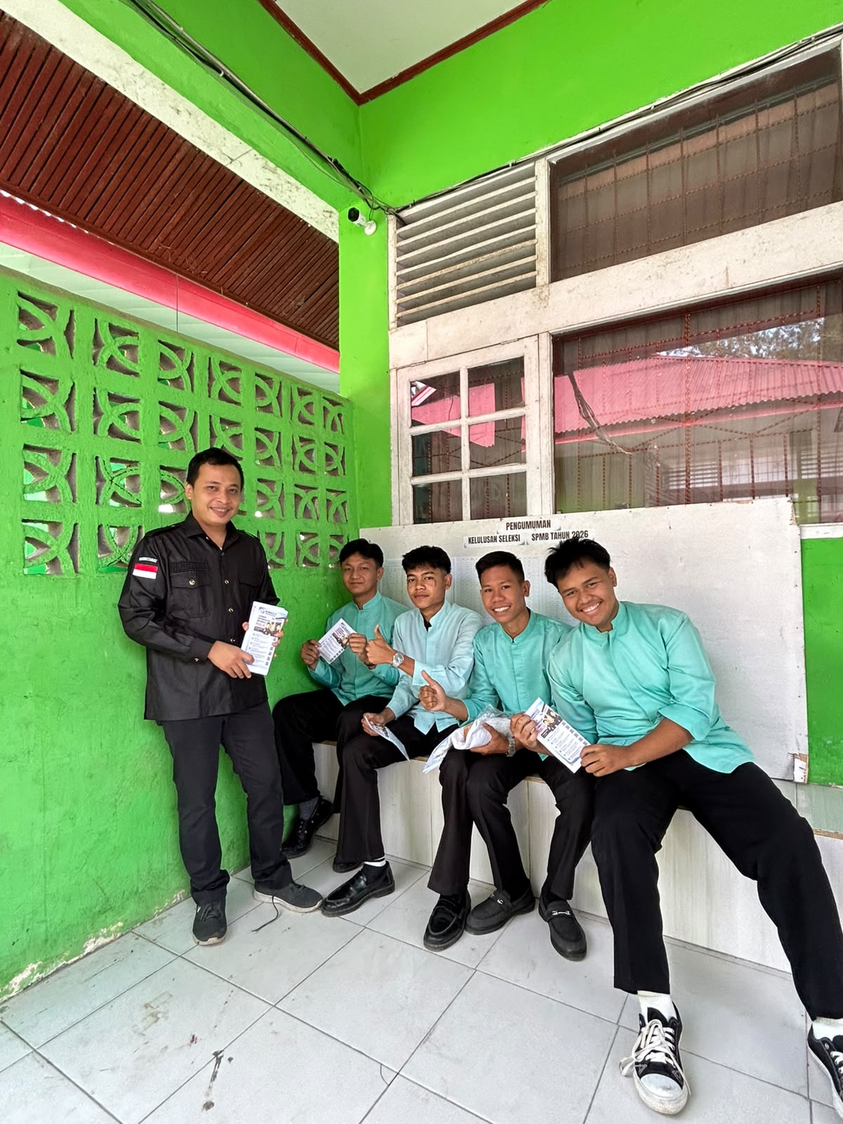 Ridho Mugraha (Staf Sekretariat) membagikan brosur PPID di SMAN 1 Bonjol