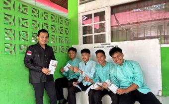 Ridho Mugraha (Staf Sekretariat) membagikan brosur PPID di SMAN 1 Bonjol